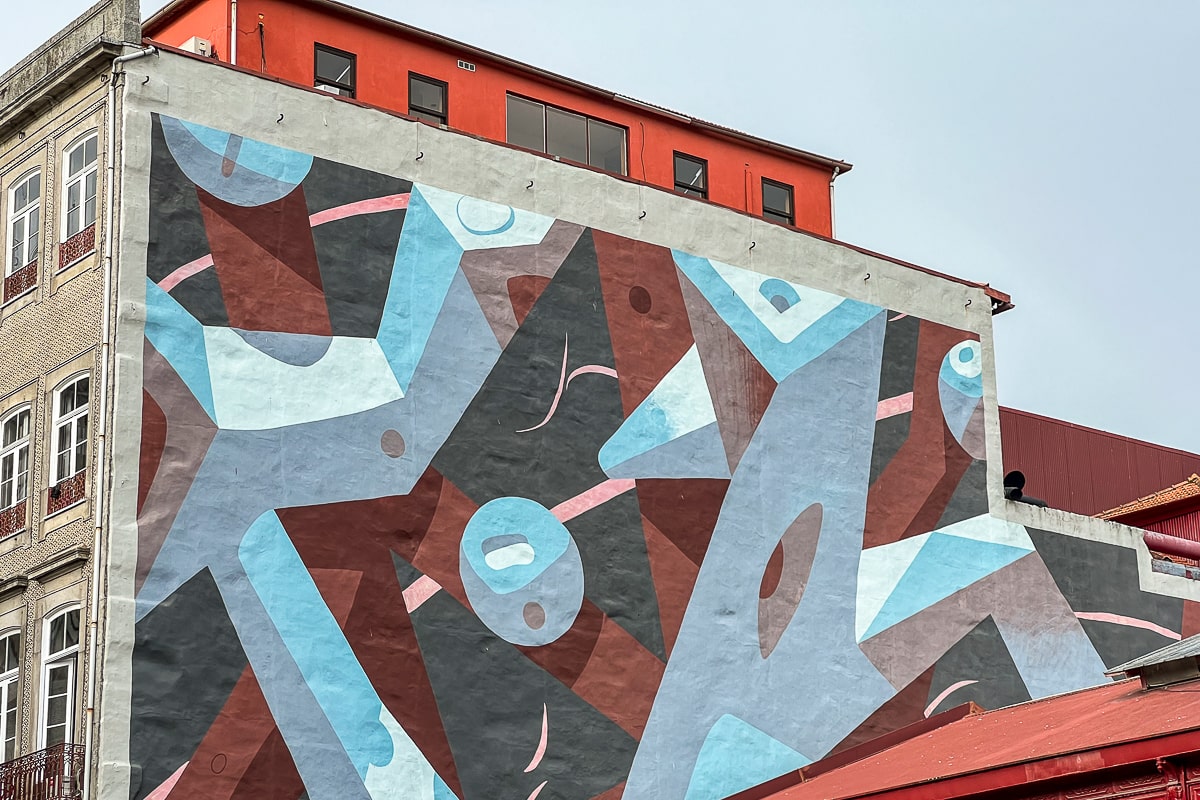 A geometric street art painting in light blues, red, and grey