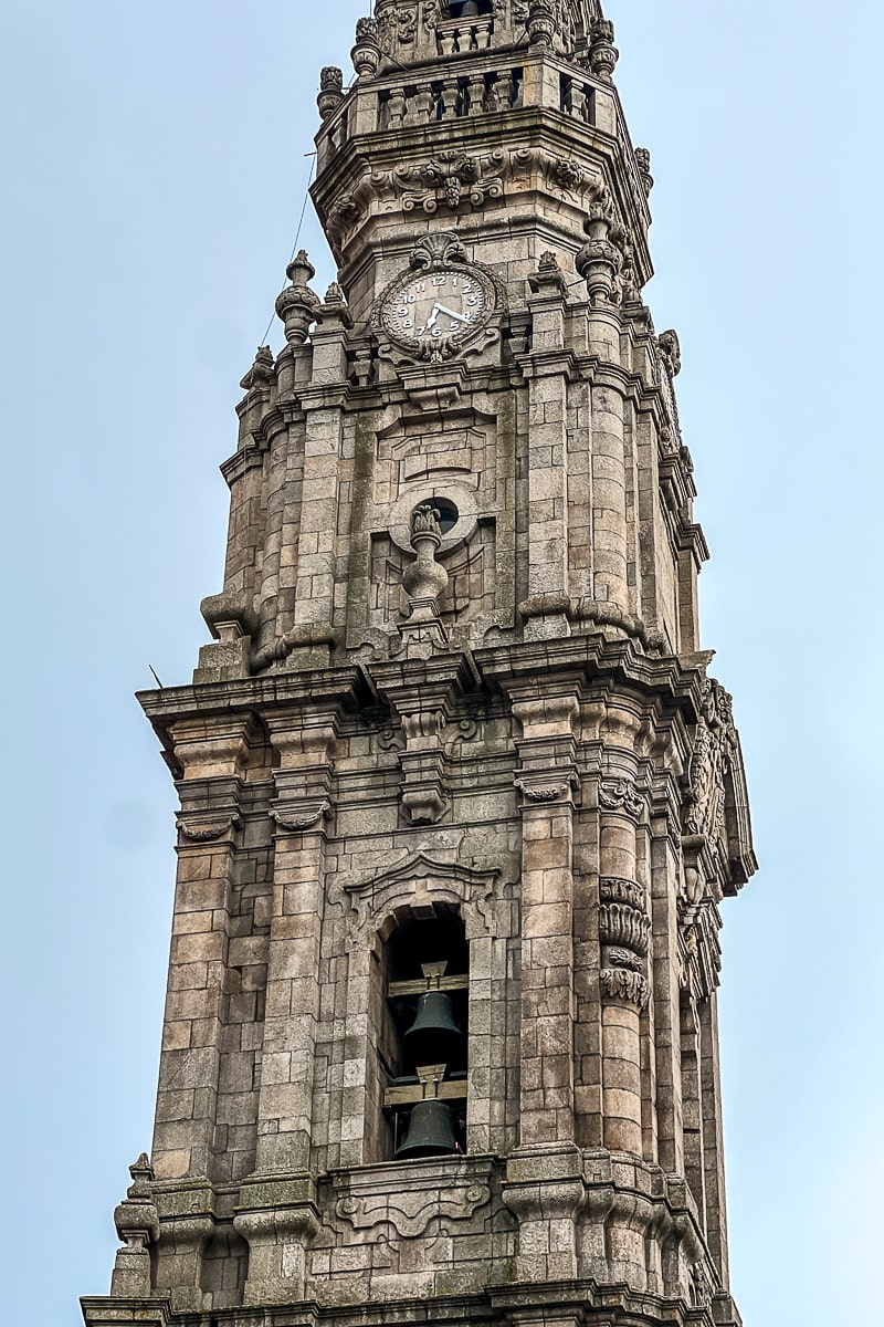 A close up of a stone bell tower and clock