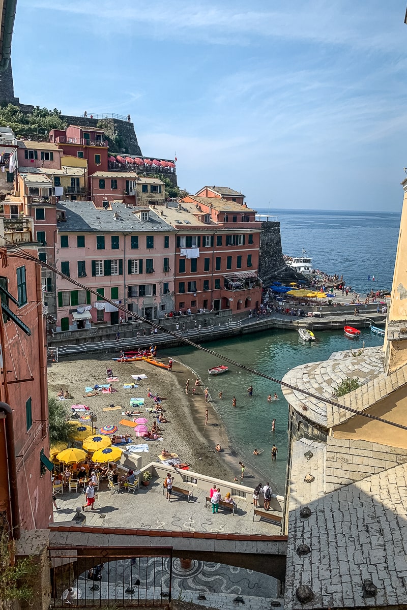 A view through tall colorful buildings of a protected beach in an Italian town