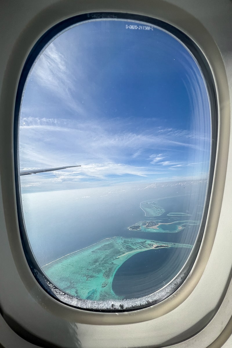 A view from an airplane window of an atoll of Maldives islands