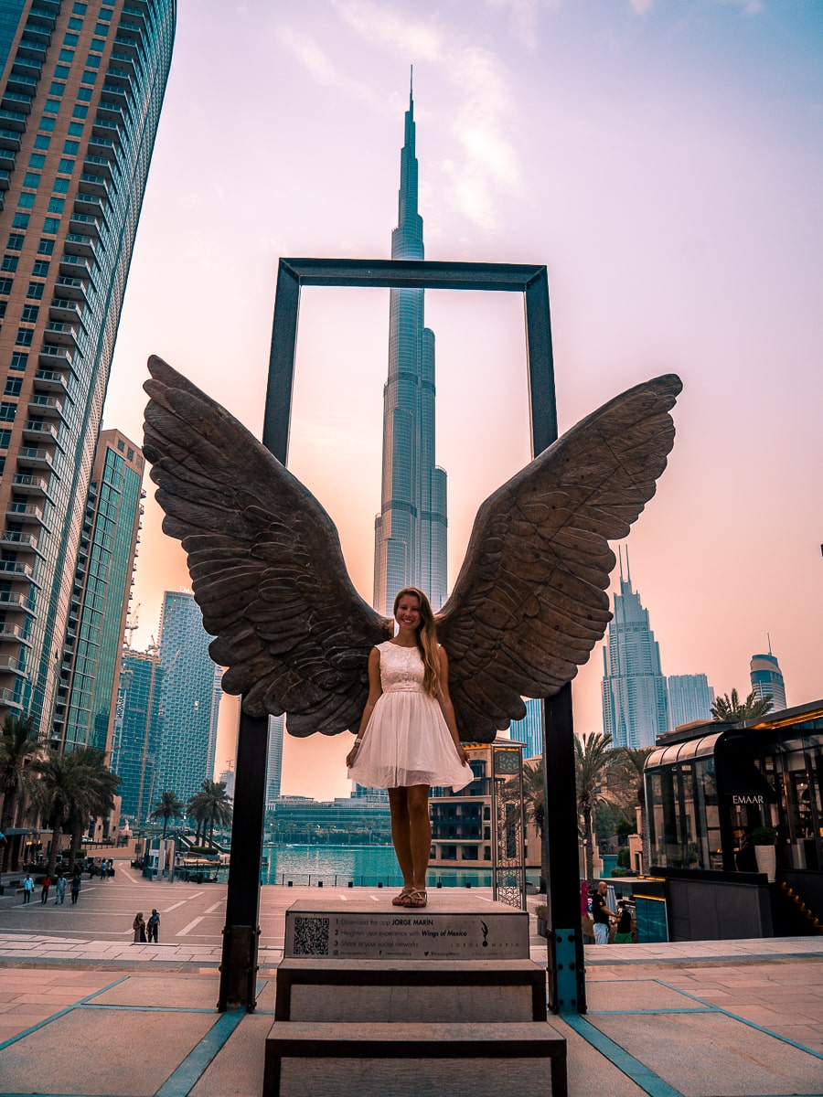 A girl in front of The Wings of Mexico in Dubai with the Burj Khalifa behind