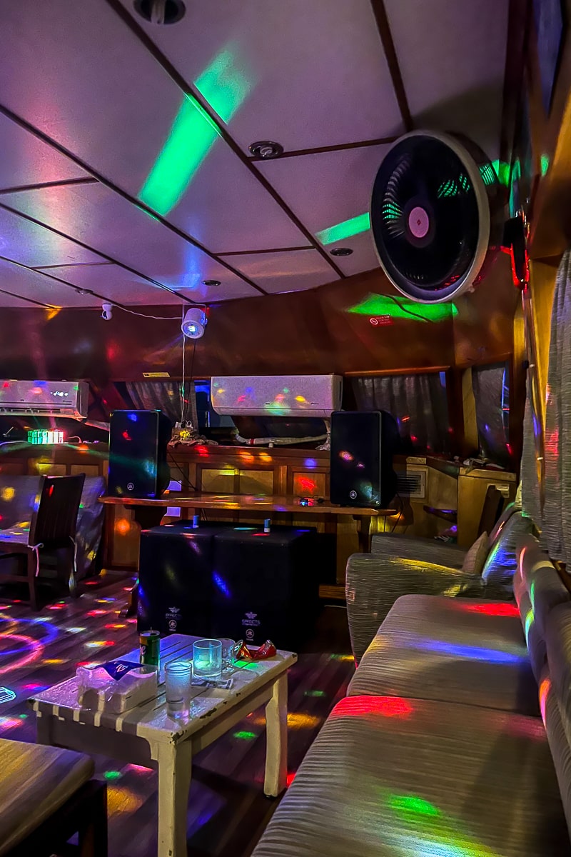 An old style wooden dancefloor of a bar with red, blue, and green disco lights