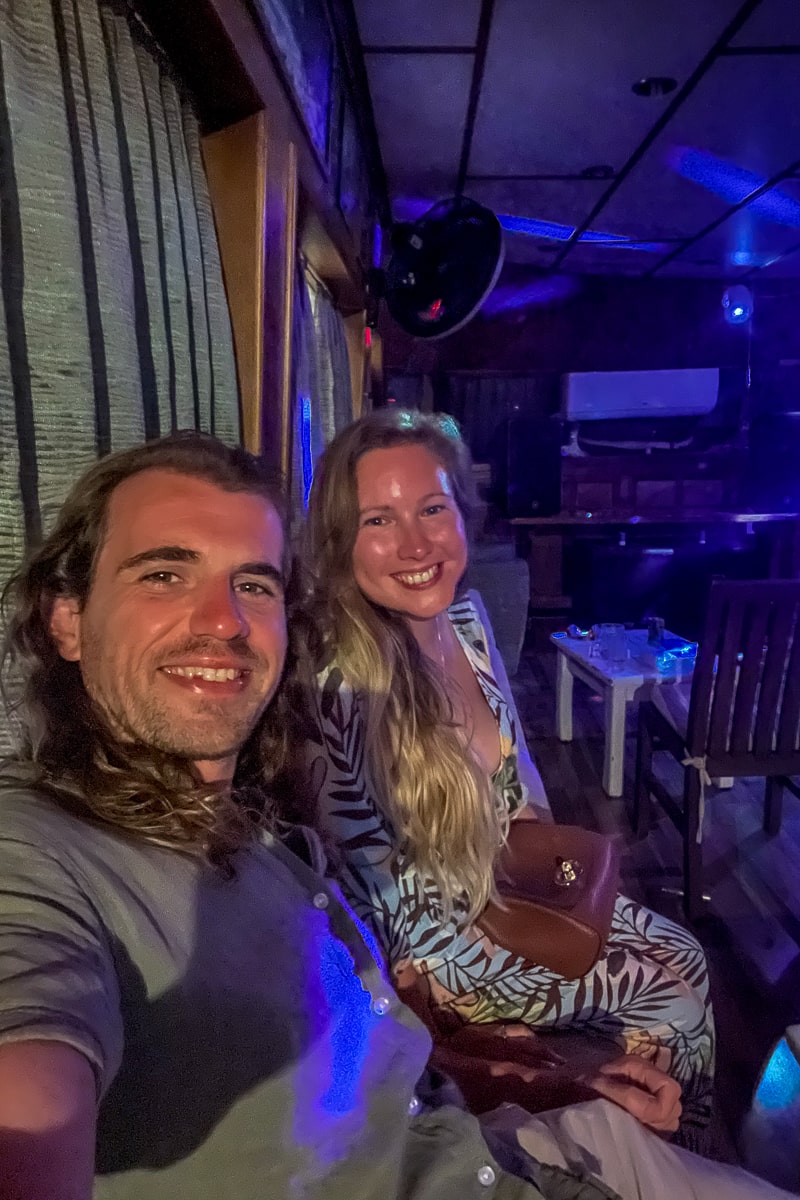 A selfie of a couple in a bar with blue and purple disco lights