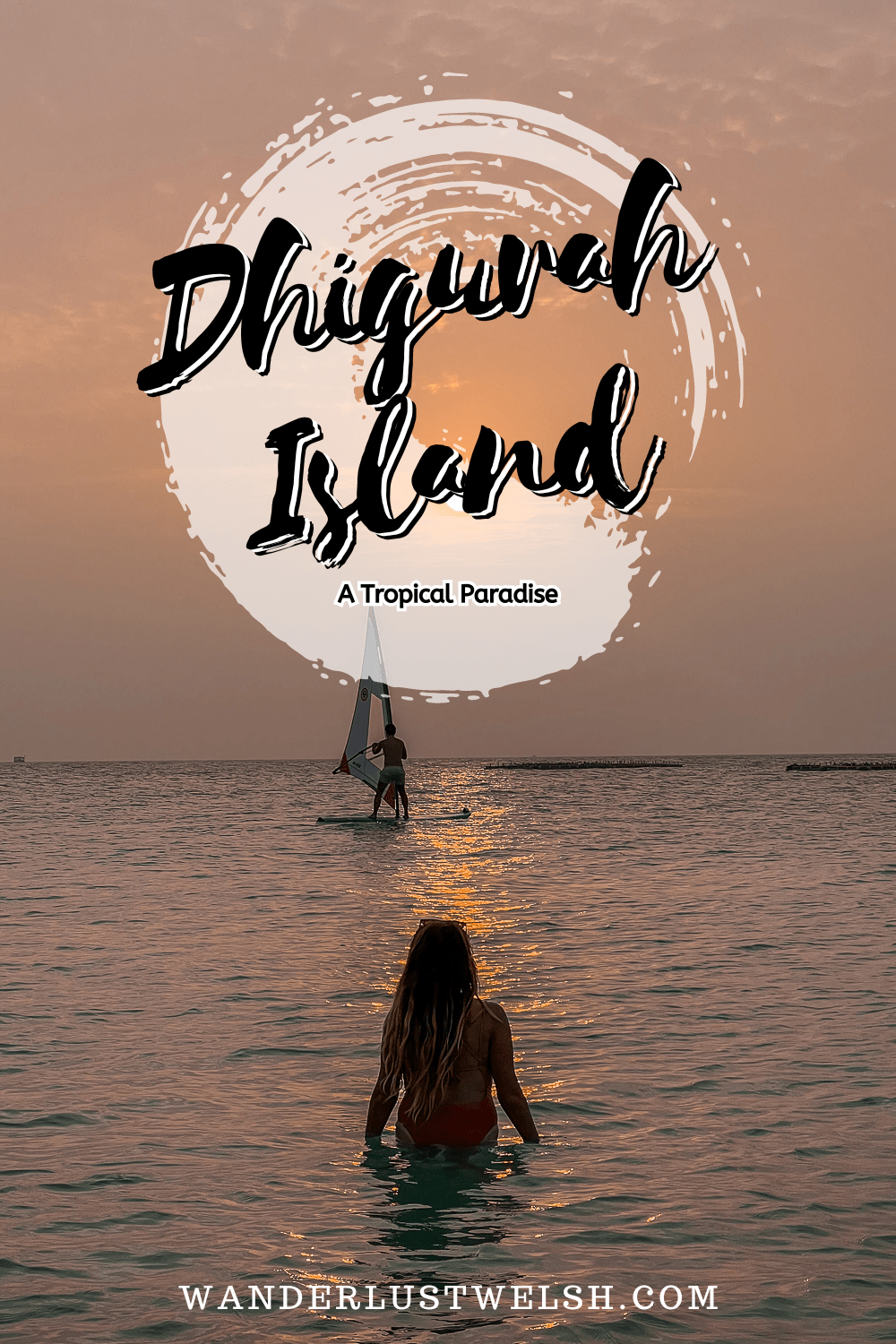 A girl bathing in the sea with a windsurfer in the background at sunset