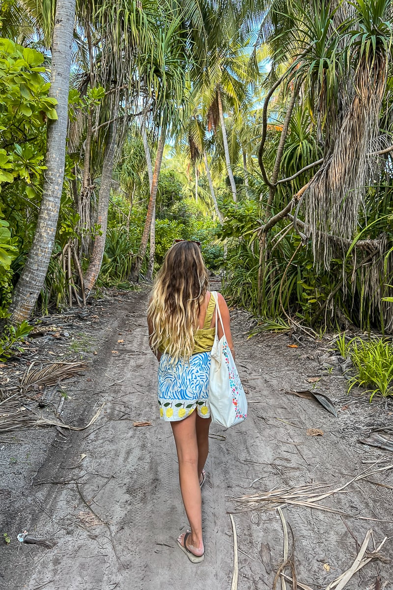 A girl walking through the jungle on Dhigurah
