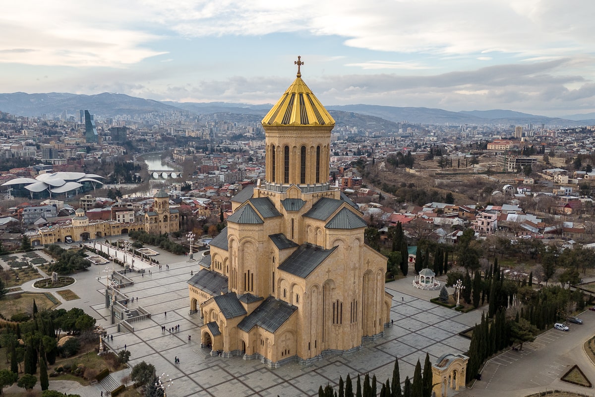An enormous Eastern Orthodox cathedral with a golden roof overlooking Tbilisi