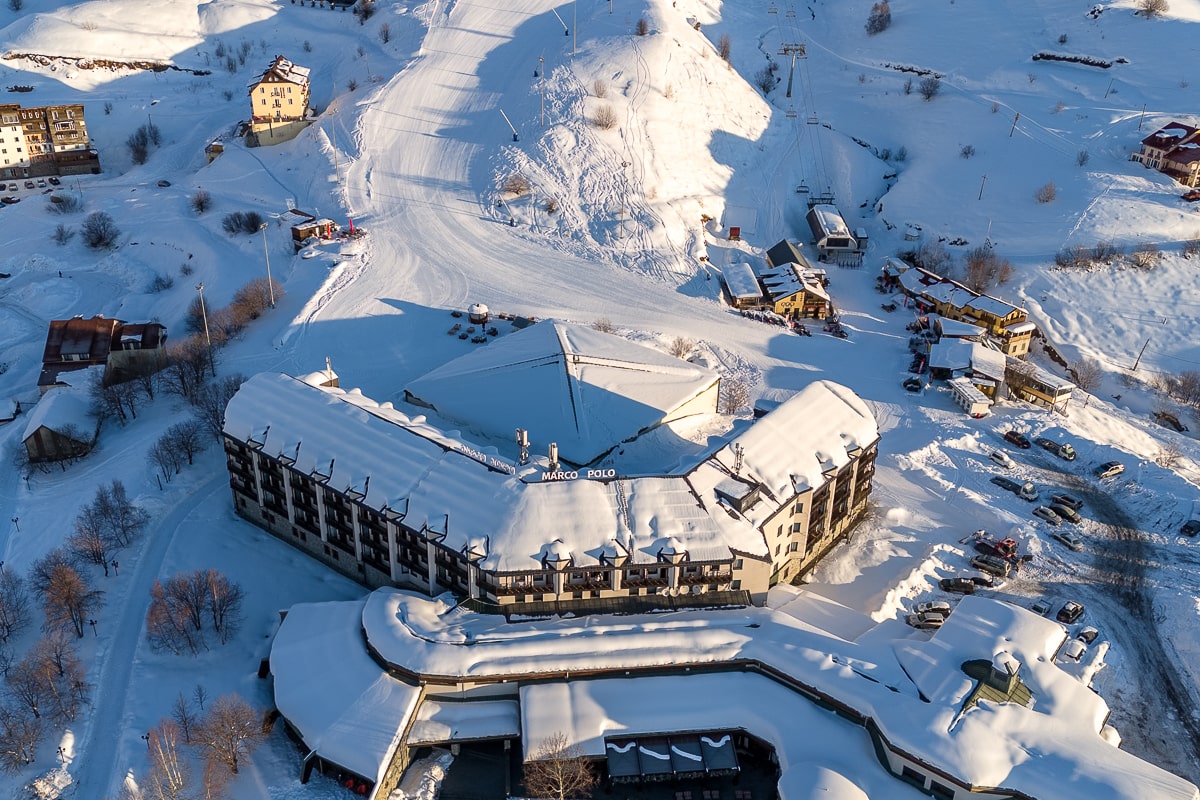 An aerial shot of the Marco Polo hotel in Gudauri ski resort covered in snow