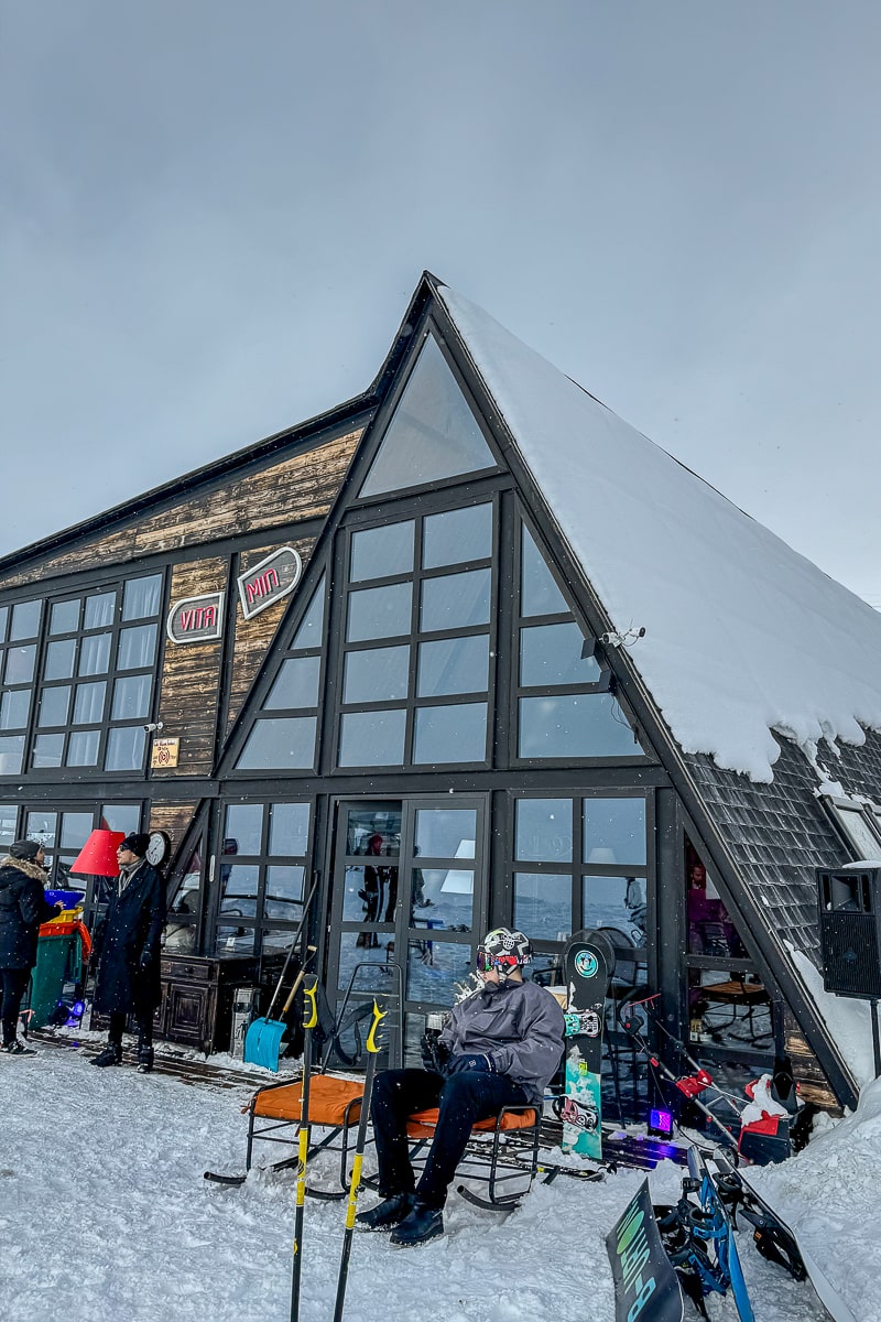 A restaurant on a ski slope that resembles a greenhouse with a pyramid shape
