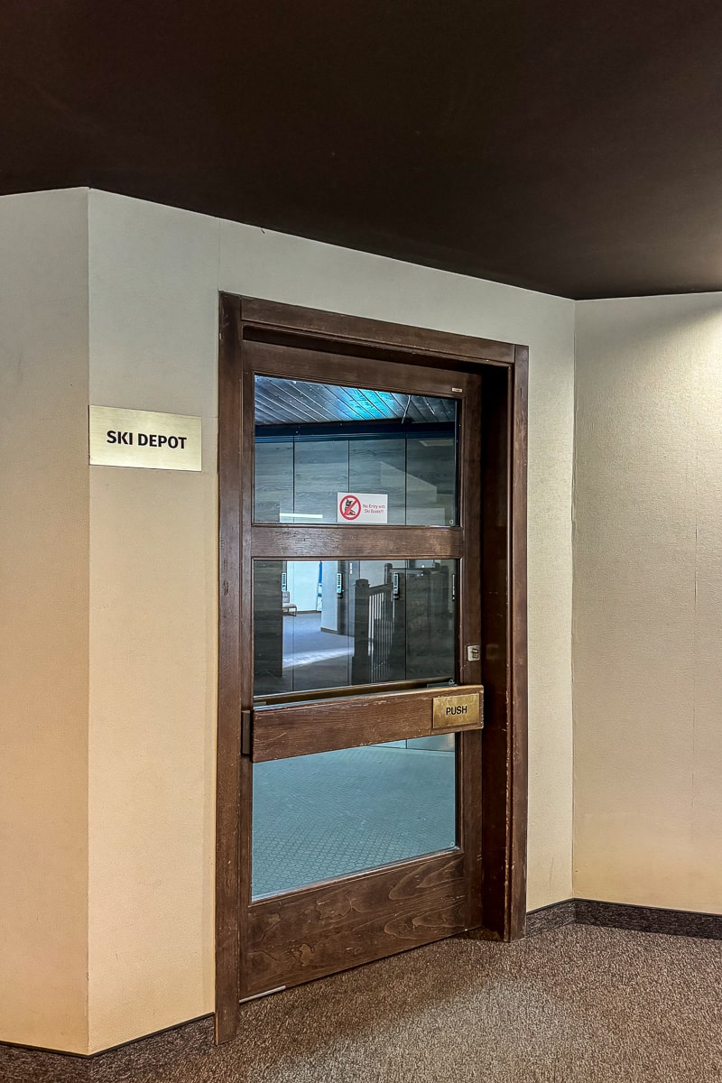 A wooden door with window next to a sign that reads "ski depot"