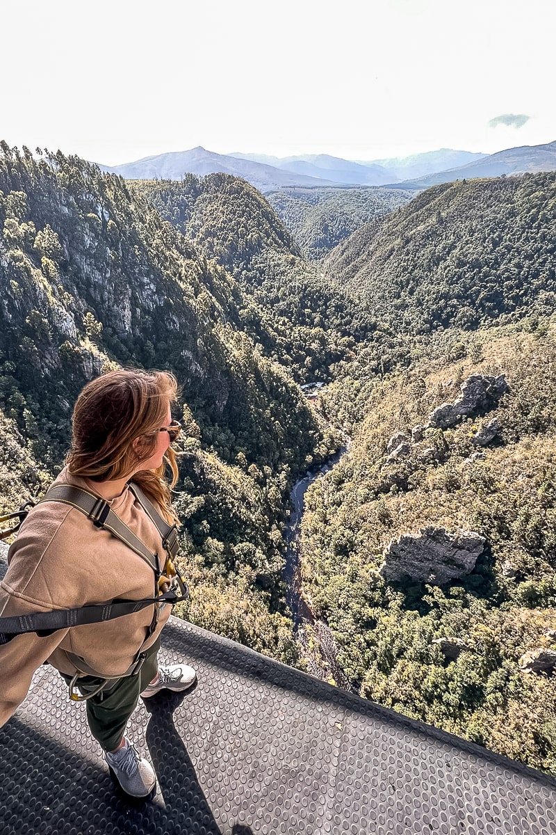 A woman looking over the edge of a drop from a bridge