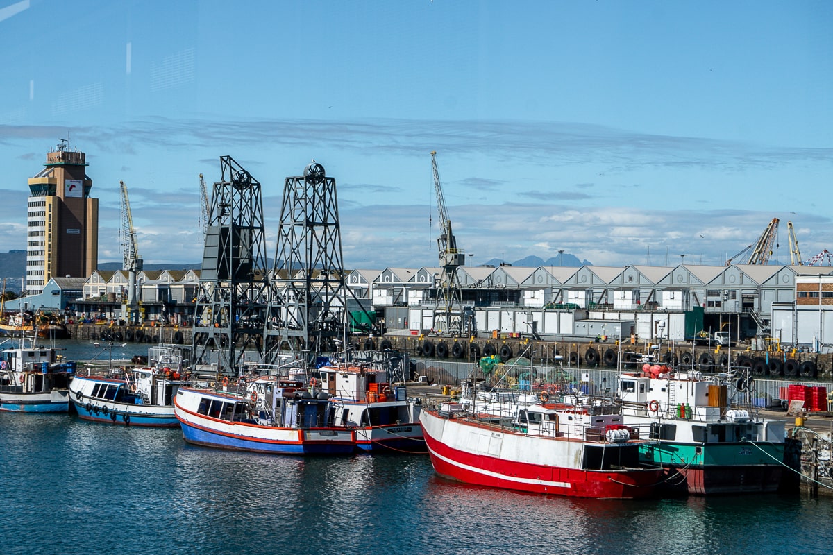A collection of boats and cranes at a shipping port