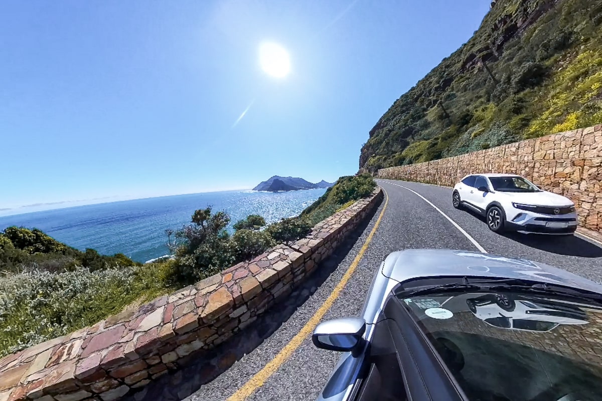 A wide angle shot from a car window along a coast road