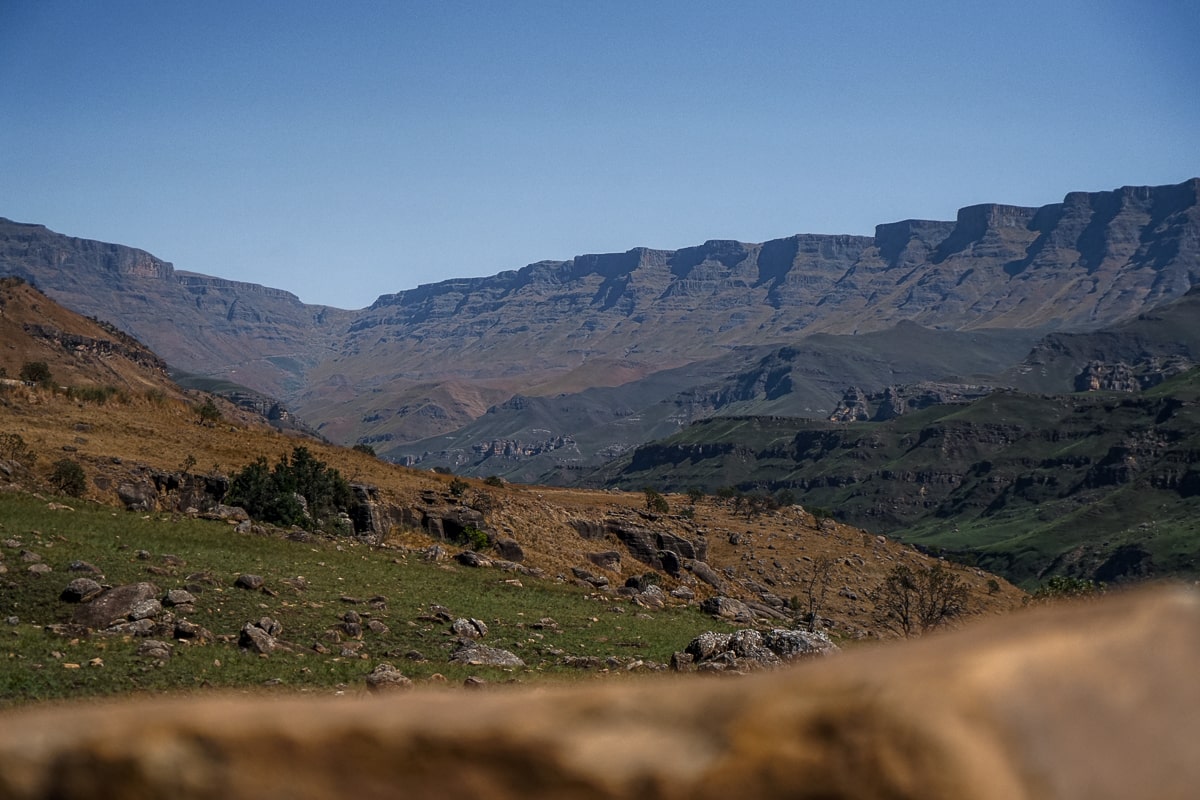 Dark Drakensberg mountains with grass and rocks in the foreground