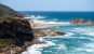 A rocky coast with blue ocean waves crashing on the rocks