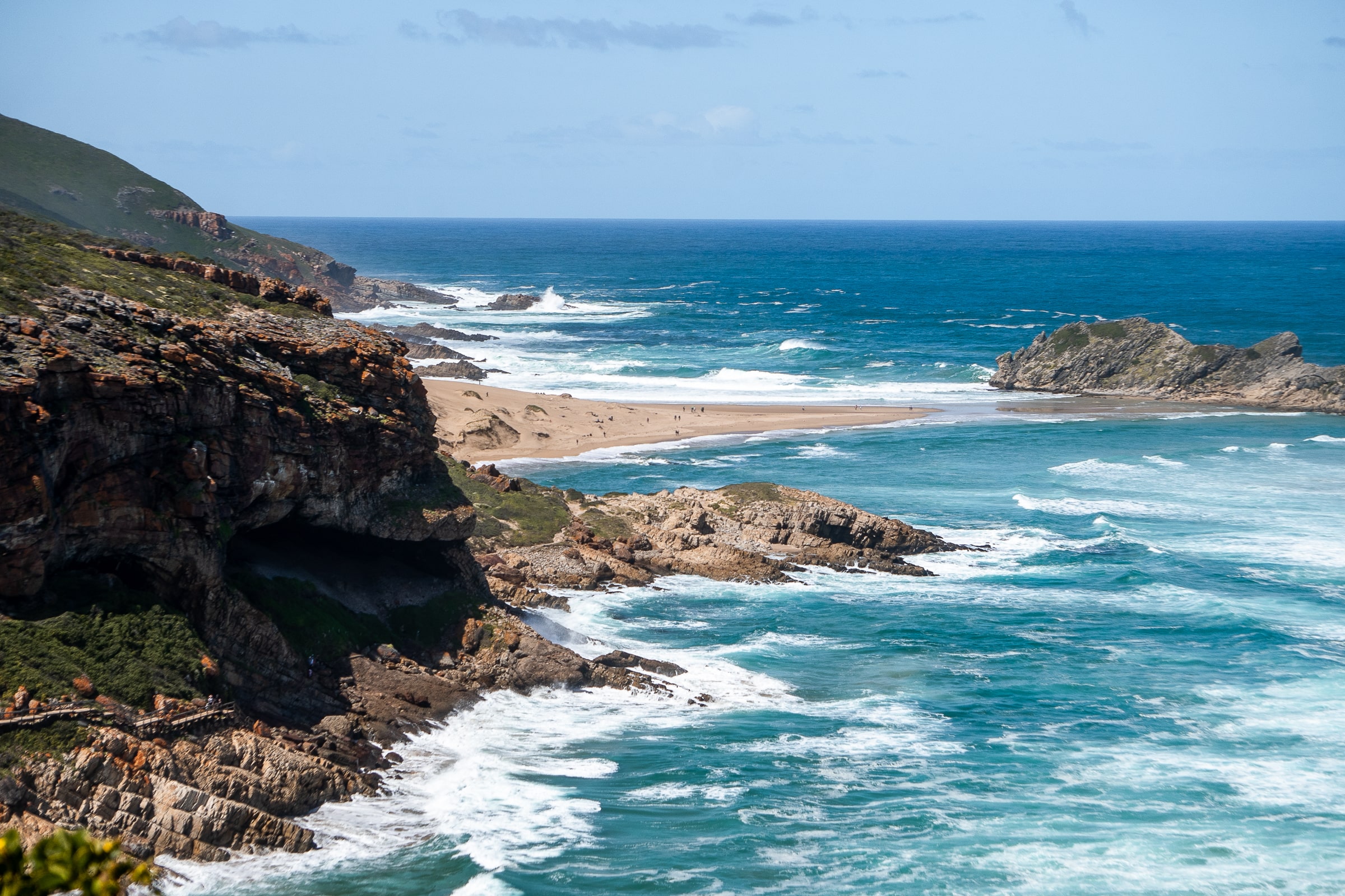 A rocky coast with blue ocean waves crashing on the rocks