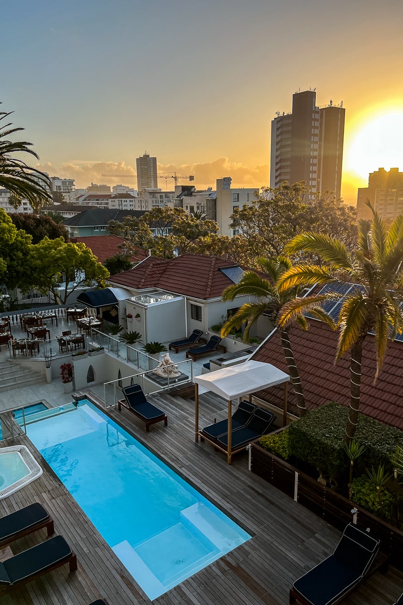 A sunset view of a hotel pool in Cape Town