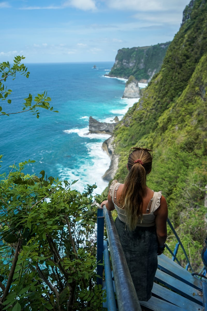 A woman stood on steep metal steps overlooking steep grassy cliffs
