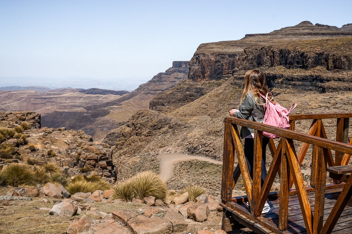A woman on a wooden balcony looking out over the Sani Pass