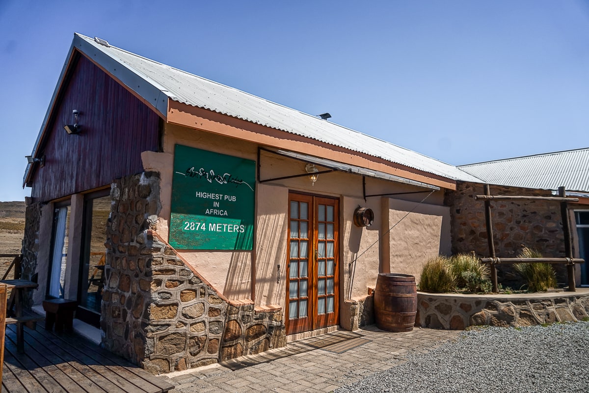 The outside of a stone and render pub with the sign reading "Highest pub in Africa - 2874 meters"