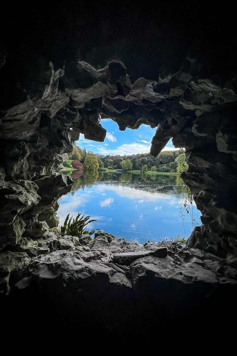 A carved hole in a rockface looking out on a lake in an Italian Grotto