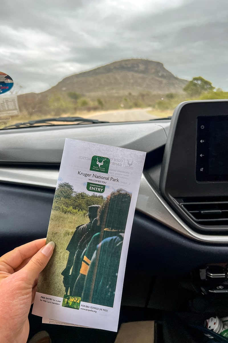 A woman holding a Kruger National Park information and map booklet