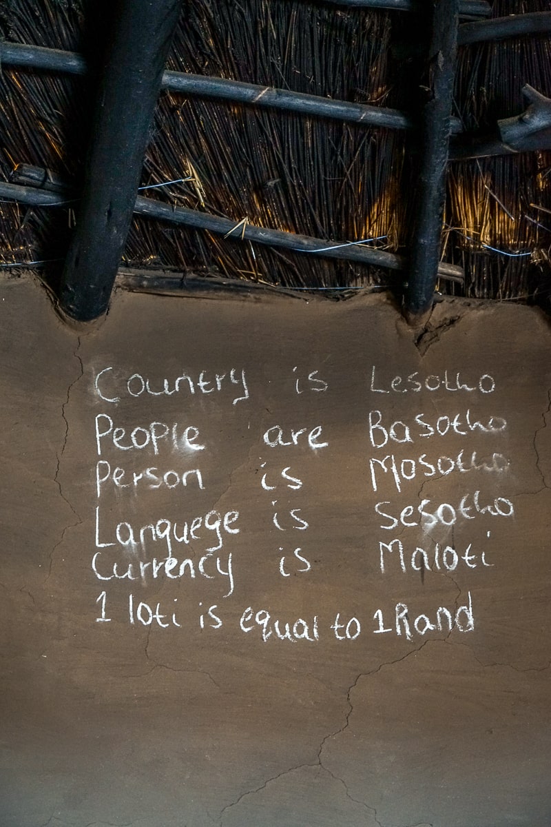 Chalk writing on a mud with some translations to Lesotho's language Sesotho