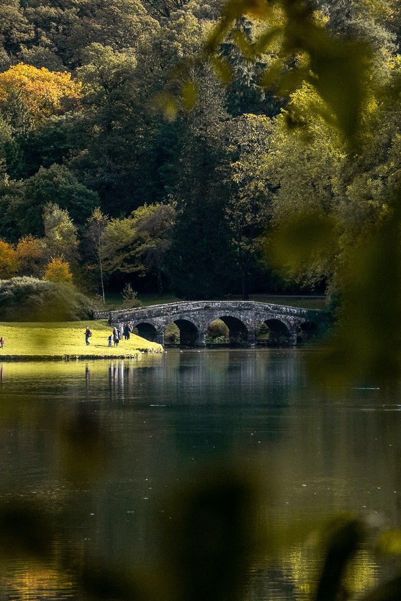 A Palladian bridge in Stourhead Gardens surrounded by trees