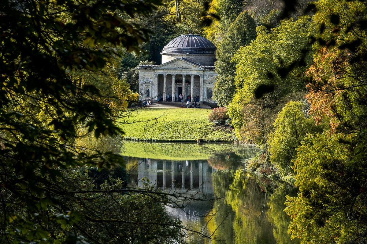 The neoclassical pantheon at Stourhead surrounded by trees and a lake