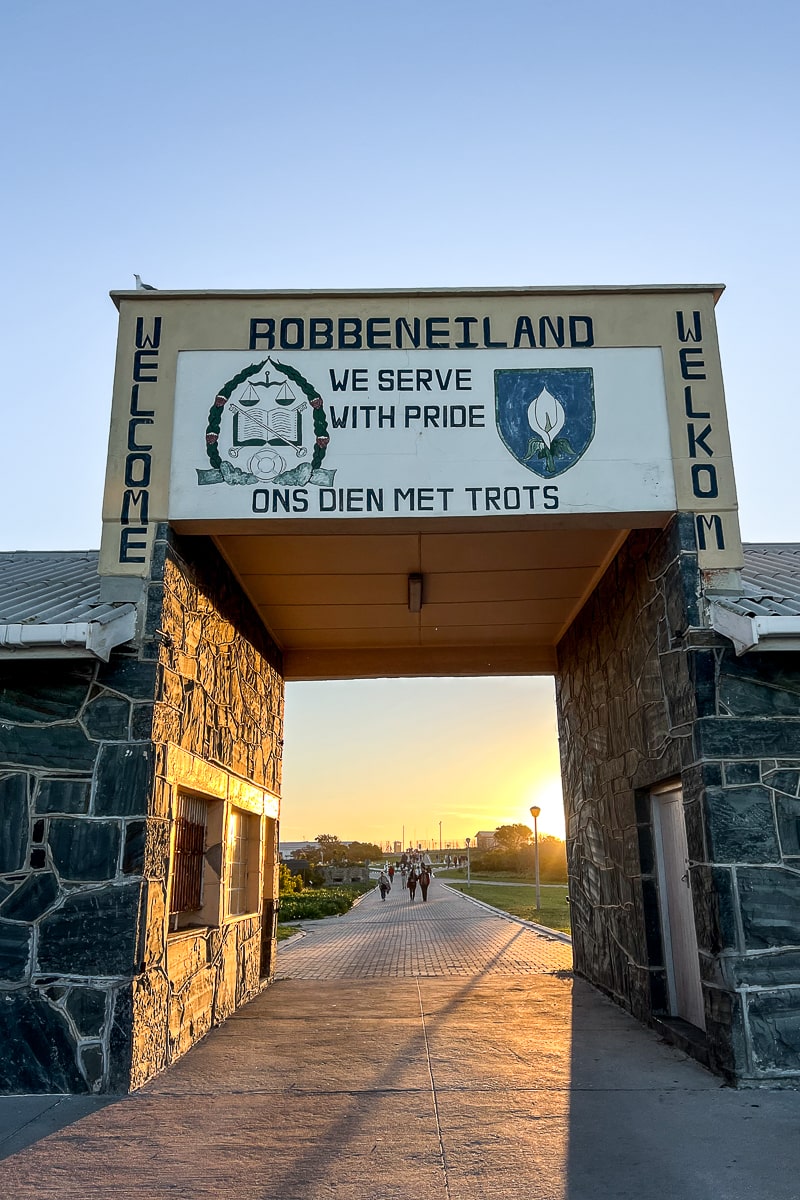 The entrance sign to Robben Island prison with the phrase "we serve with pride" in English and Afrikaans