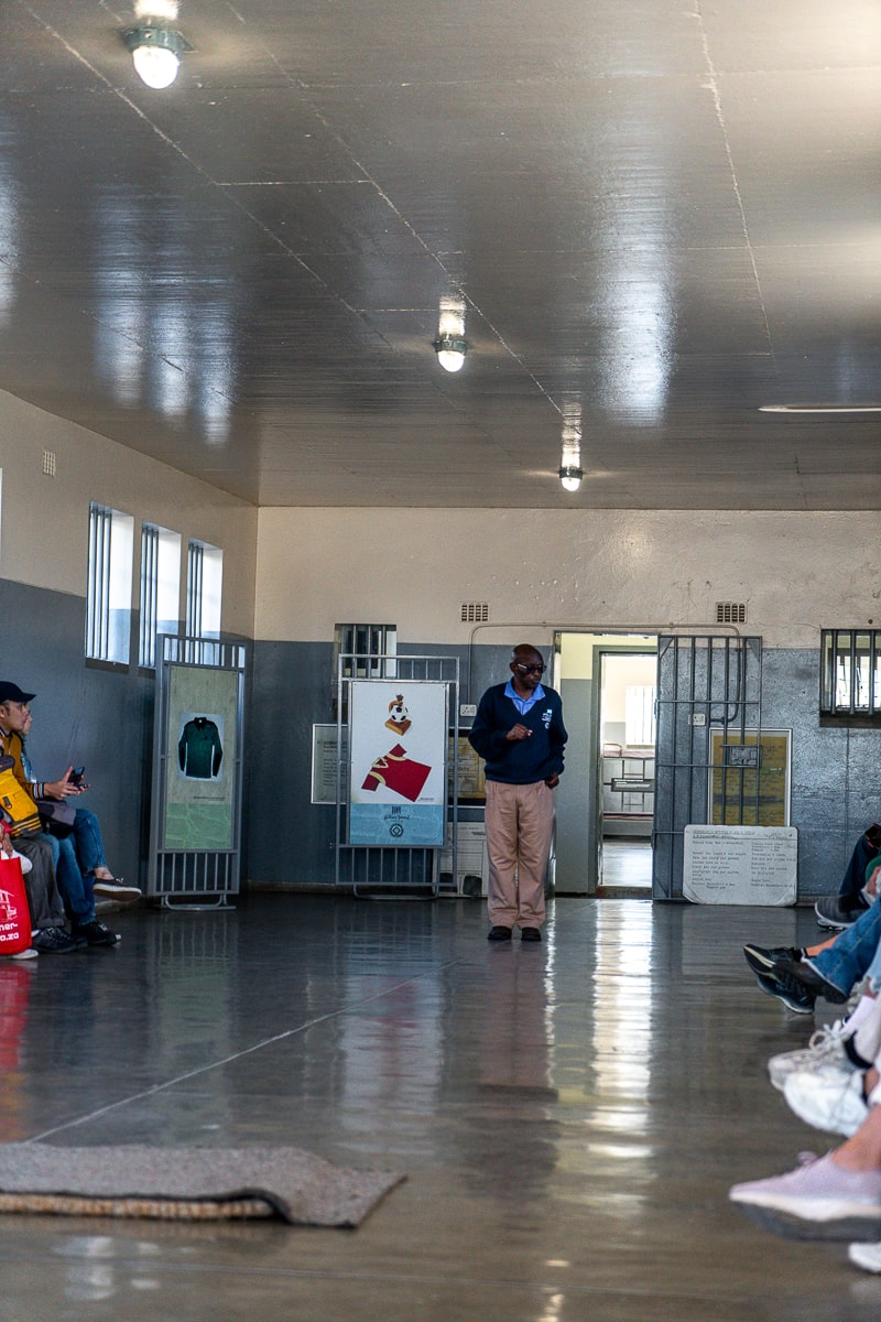 A man giving a talk to a group inside a prison