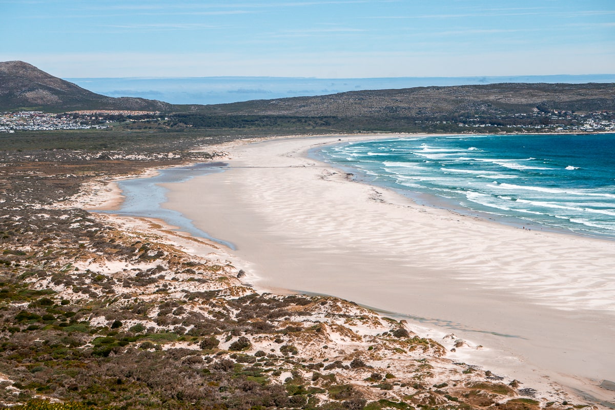 A sandy bay with bright blue ocean waves