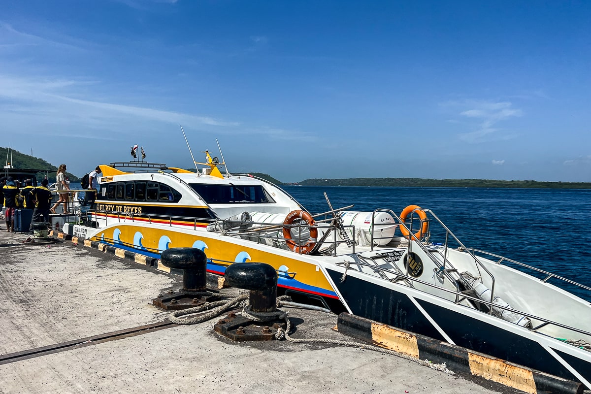 A yellow and black speedboat style ferry docked at a concrete pier