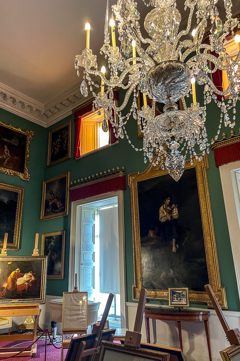 A room with chandelier and portraits
