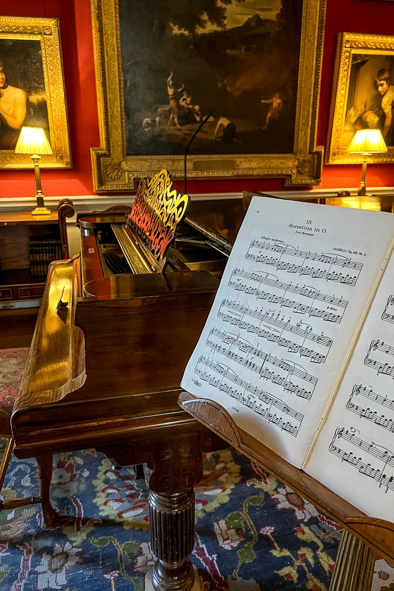 A brown wooden piano and sheet music