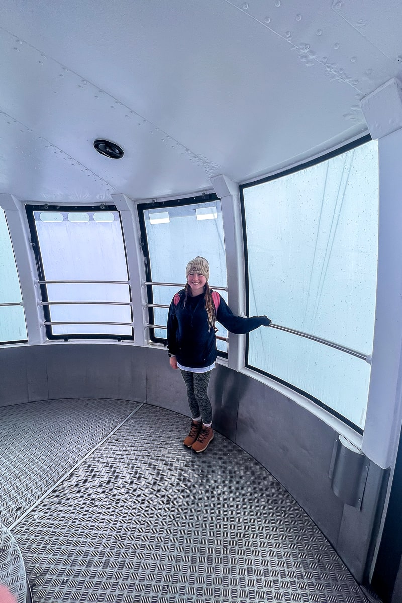 A woman stood inside a gondola on a foggy day