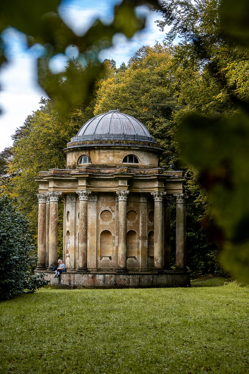 A neoclassical temple framed by a tree branch