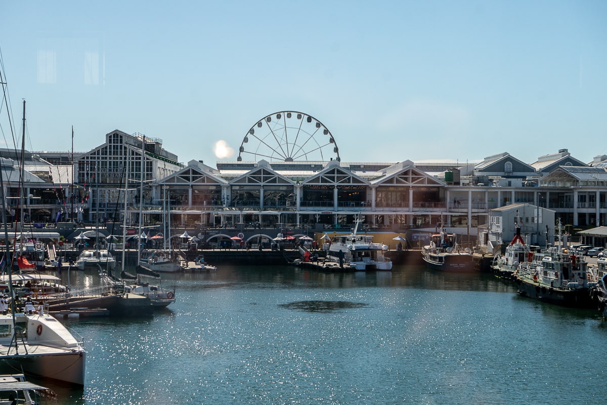 A waterfront with boats and a ferris wheel
