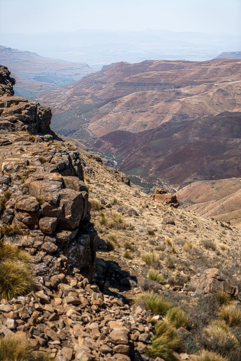 A view of a grassy valley and rocky cliffside