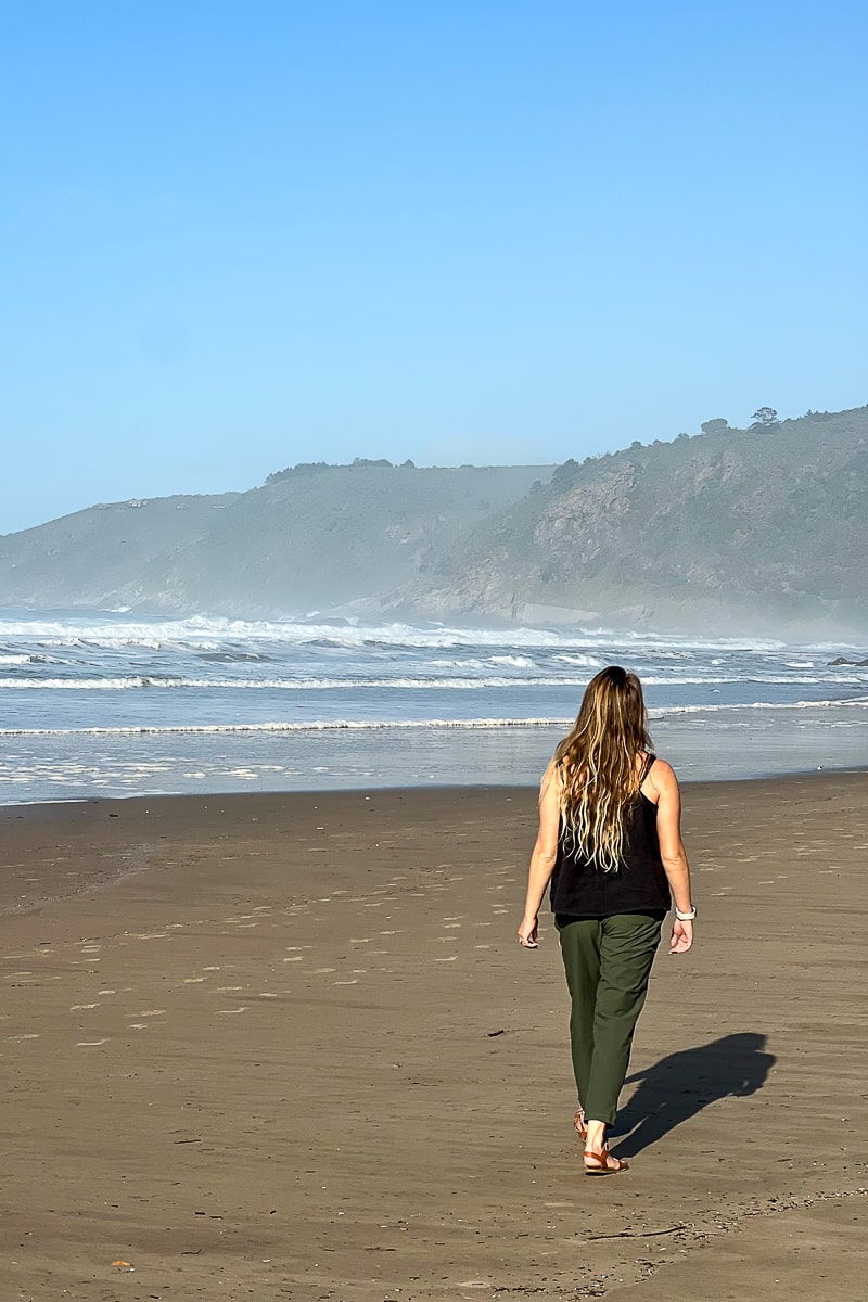 A woman walking on a sandy beach