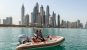 A couple on a mini speedboat in front of Dubai's skyline