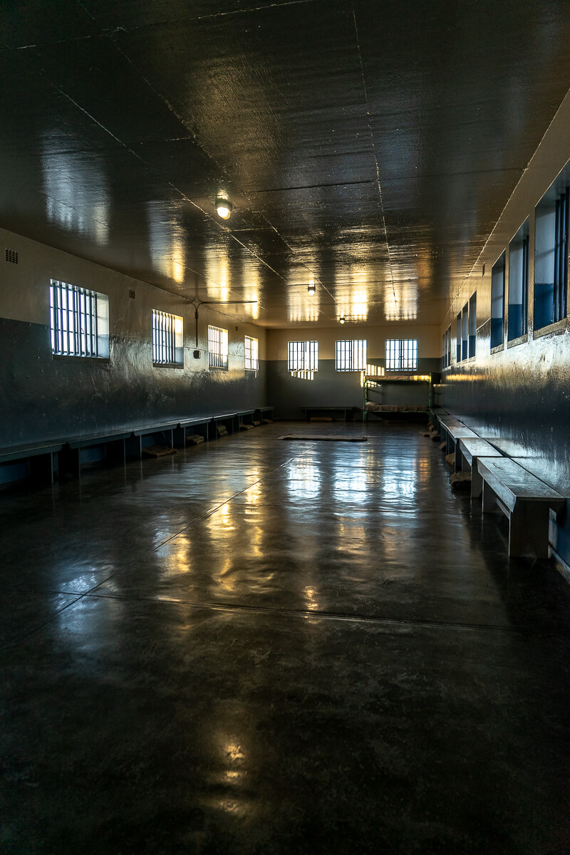 Inside a large communal cell with small windows and the sun setting outside