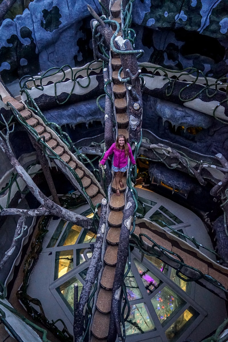 A woman standing on a raised platform of stairs in a haunted house