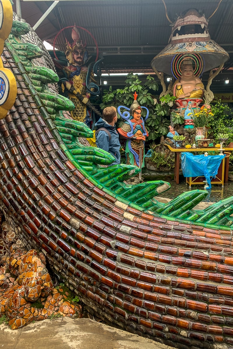 A part of a large dragon structure made from glass bottles in a Vietnamese temple complex