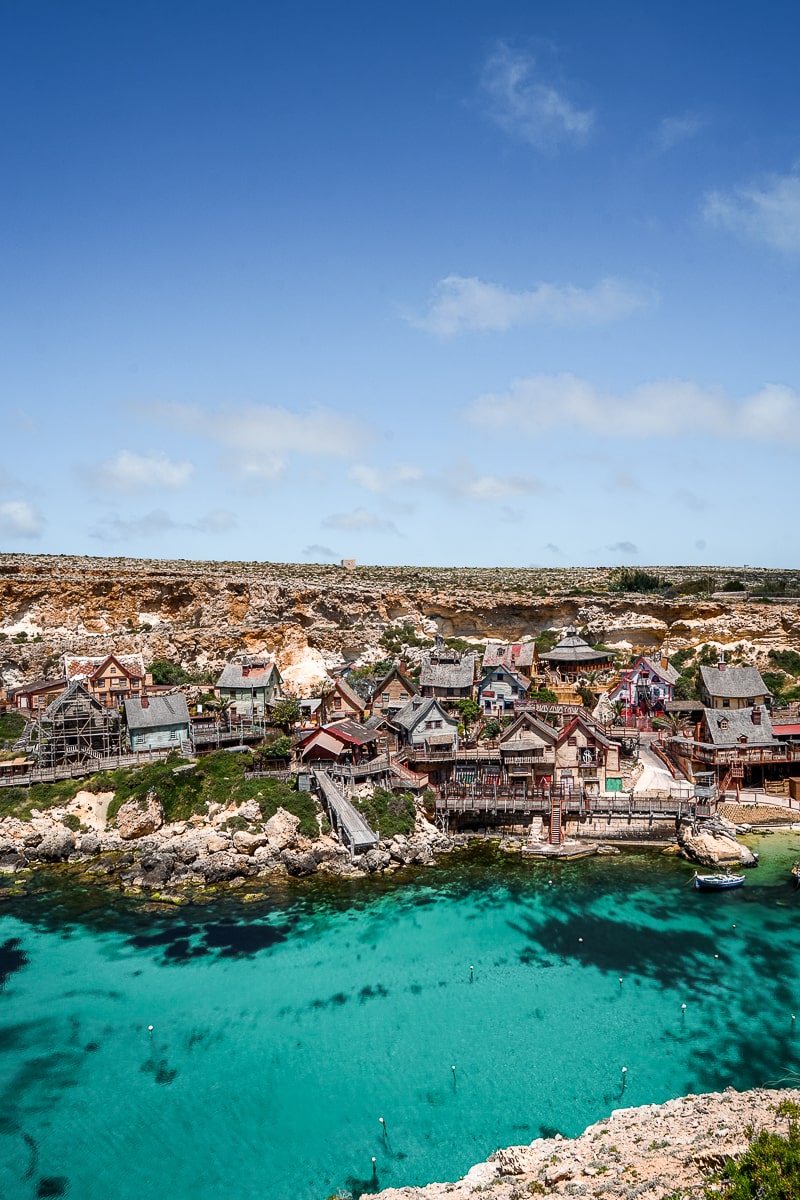 A movie set of Popeye village with clear blue sea