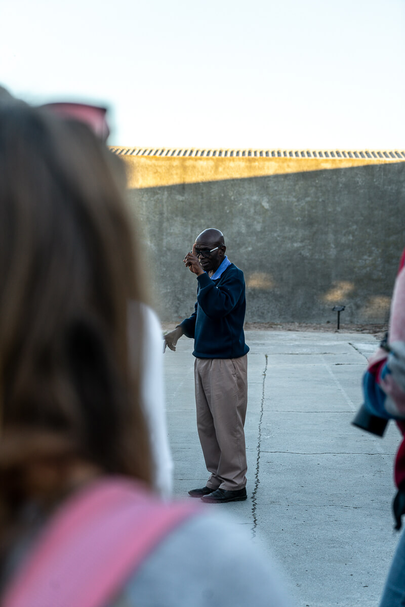 A man giving a talk in a prison yard