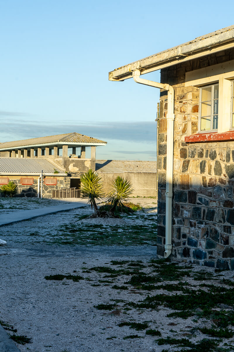 A grey stone prison block and guardtowers