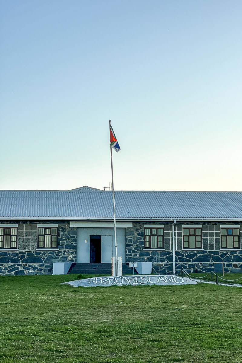 A prison block entrance with a South African flag on a pole
