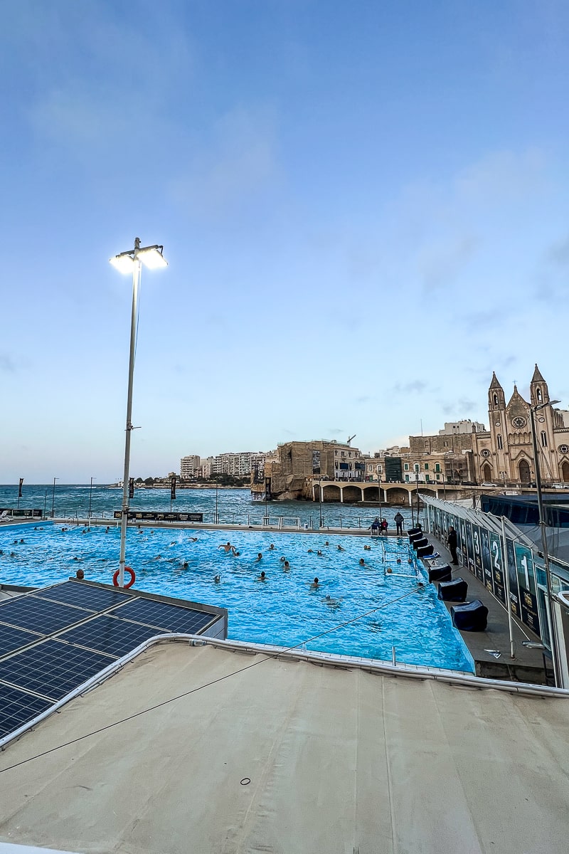 A packed outdoor pool overlooking the sea