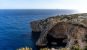 A natural rock arch over the blue sea