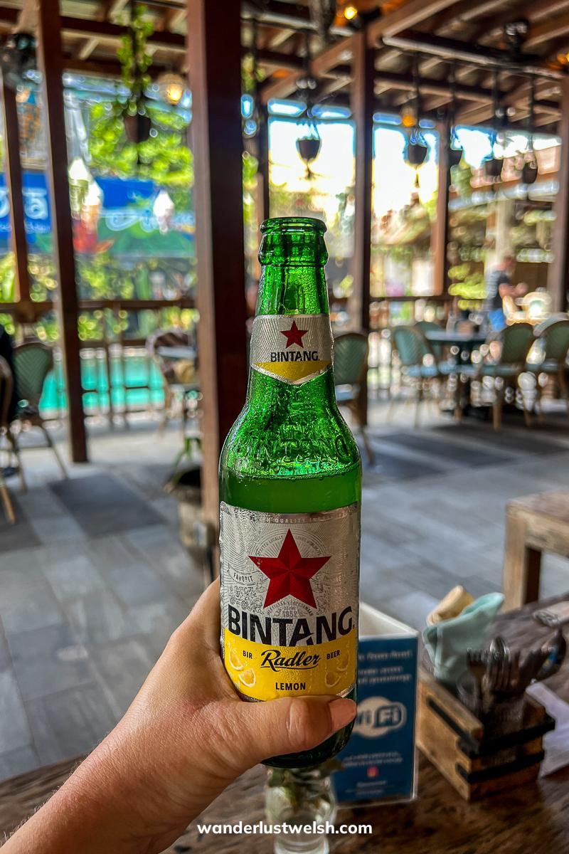 Someone holding a Bintang Radler beer bottle